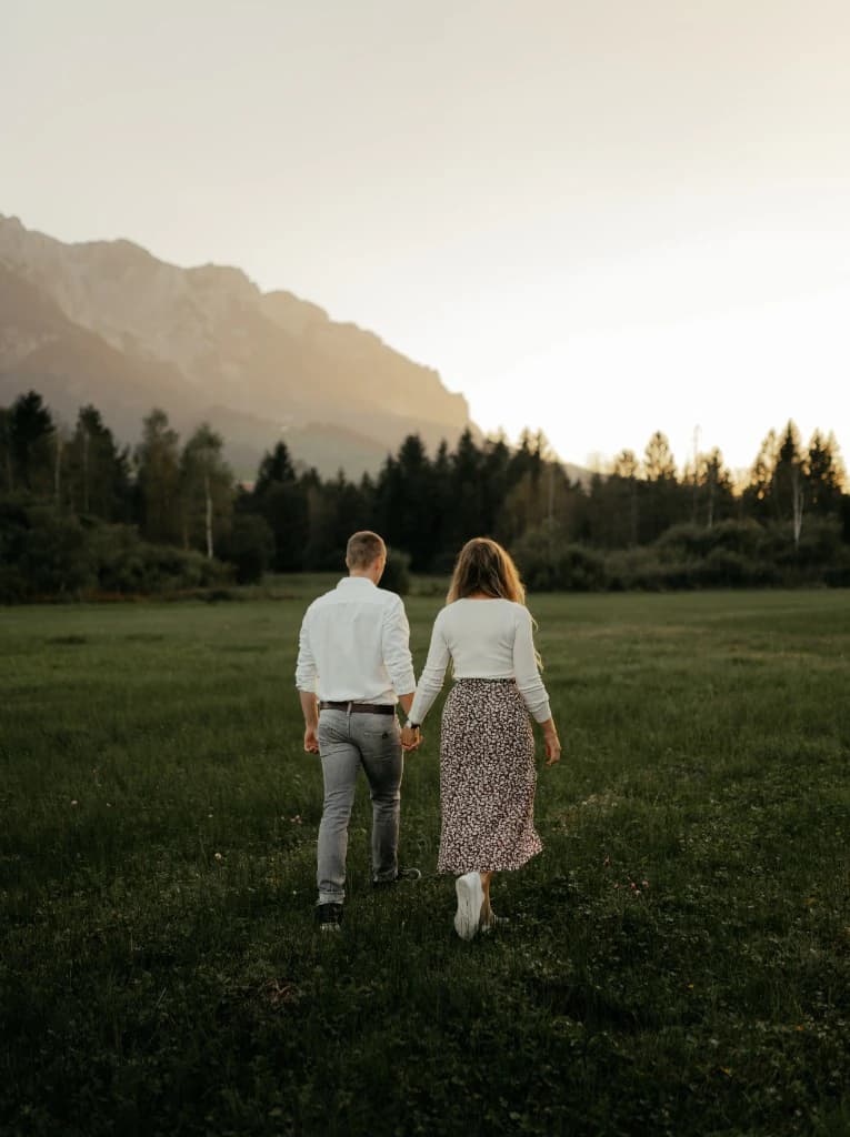 Paar wandert Hand in Hand Richtung Berge