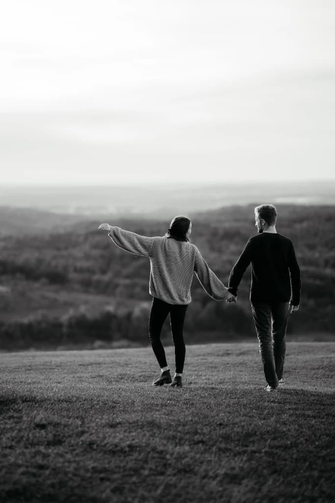 Paar wandert Hand in Hand über den Hügel