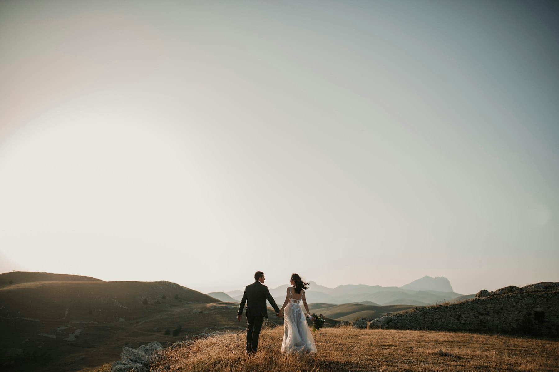 Paar Hand in Hand vor weiter Berglandschaft